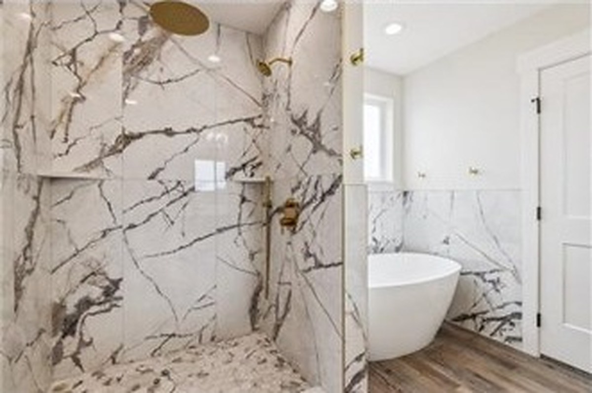 Primary bath with marble-look shower and freestanding tub