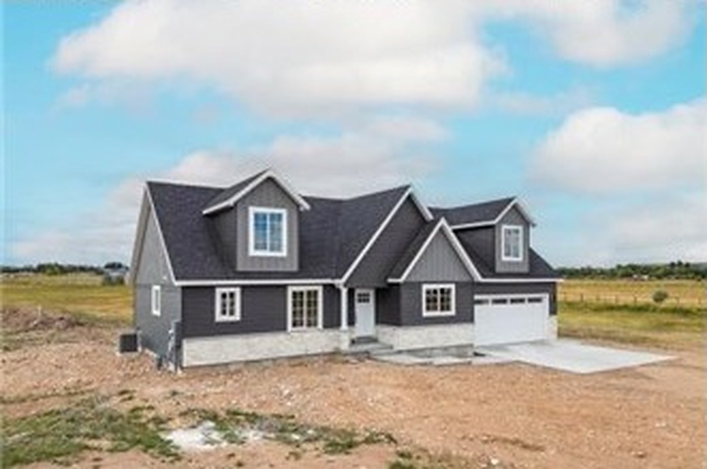 Three-quarter exterior view of Meadows — charcoal siding, stone, and white trim