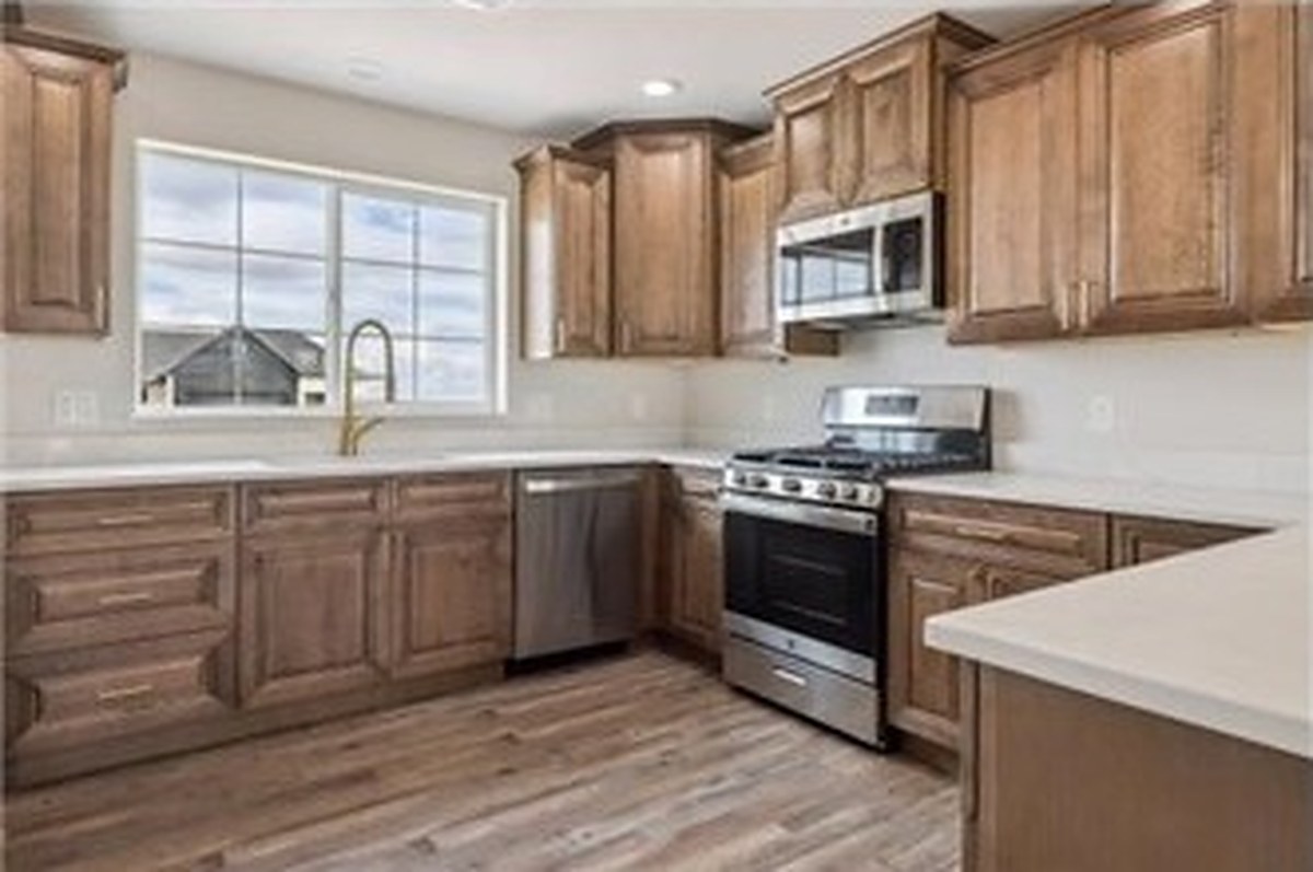 Kitchen with warm wood cabinets and white counters at Meadows